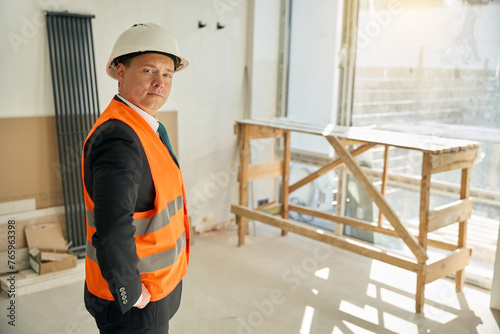 Waist up picture of male architect standing in uncompleted room