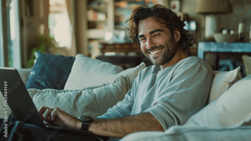 Obraz premium Stylish, modern man smiling at camera and using a tablet in his hands.