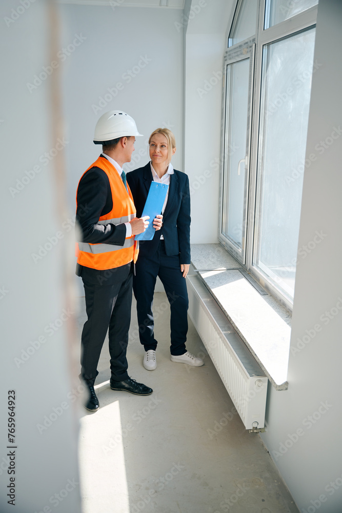 Construction manager and investor talking in room near window Construction manager and investor talking in room near window