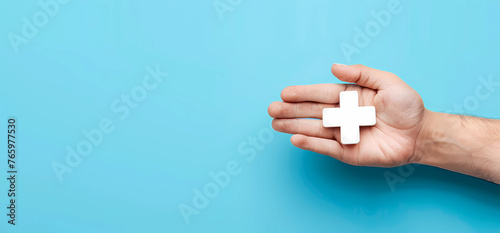 Hand holding medical plus icon with blue background
