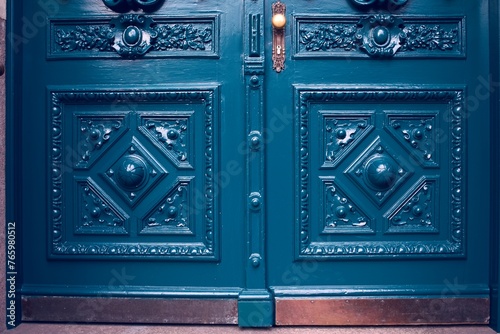 Vintage blue wooden doors with ornate carvings and brass handles. photo