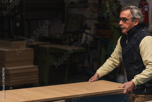 copyspace Elderly Carpenter Handling Large Wooden Board in Carpentry Workshop