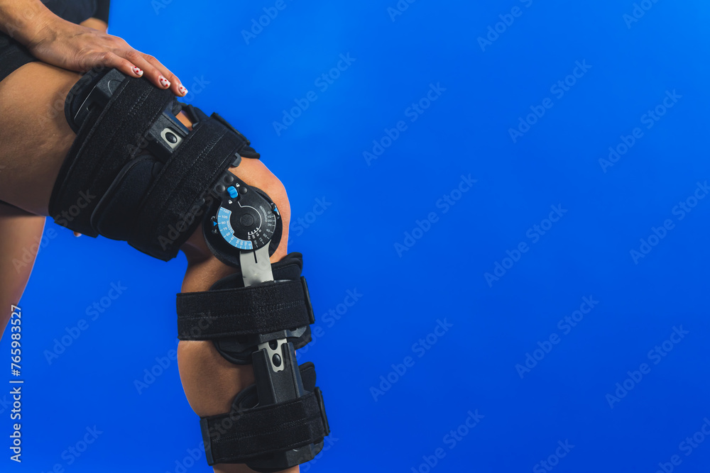closeup shot of a knee brace with angle movement controler on a leg, medical concept. High quality photo closeup shot of a knee brace with angle movement controler on a leg, medical concept. High quality photo