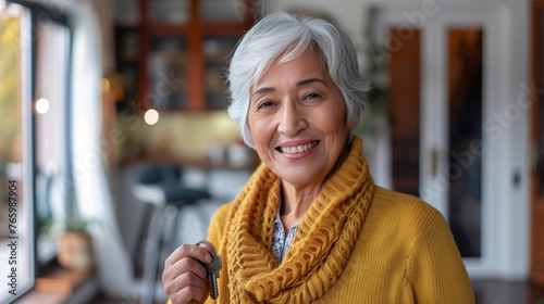 Retired woman proudly displays the keys to her new home, her smile radiant as she endorses mortgage and rental apartment agency services, as well as real estate property purchases. photo