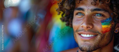 portrait of a handsomel Hispanic Latino man, with the lgbt flag painted on his cheek, concept of gay pride 