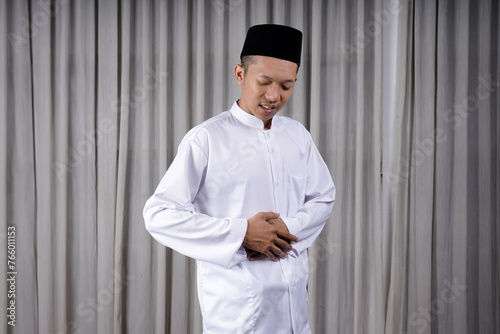 фотографія Muslim Asian man touching his stomach with in pain expression