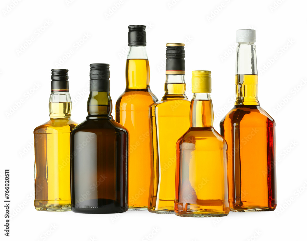 Different sorts of whiskey in glass bottles isolated on white Different sorts of whiskey in glass bottles isolated on white