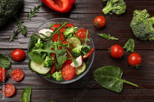 Tasty fresh vegetarian salad on dark wooden table, flat lay