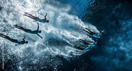 A slow-motion shot of a synchronized diving team gracefully executing a complex maneuver in mid-air, water droplets glistening around them. Depict the beauty and precision of aquatic sports.