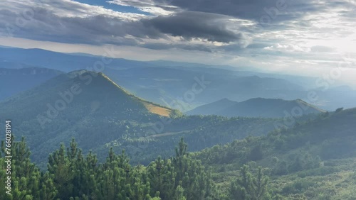 4K shot behind the spruce branches tree with a picturesque Mala Fatra mountain range in Western Carpathians. Stoh mountain 1607m in the center. Beauty in Nature and traveling concept video. photo