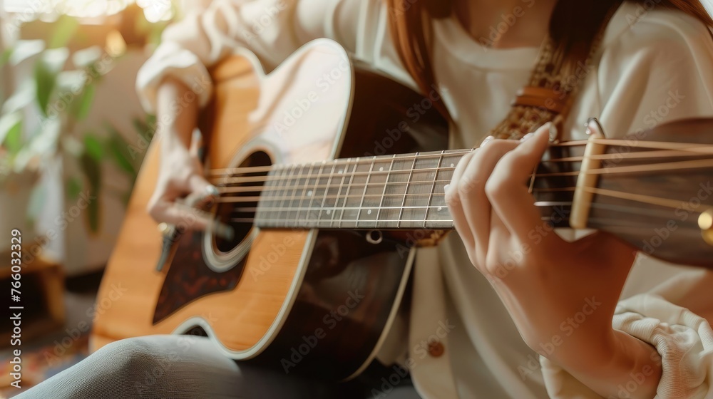 Fototapeta premium woman's hands playing acoustic guitar, close up