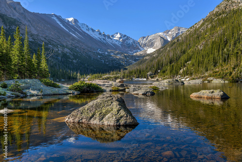 Spring Morning at Mills Lake - A Spring morning view of a rocky section of Mills Lake, with high peaks towering at south end of Glacier Gorge. Rocky Mountain National Park, Colorado, USA.