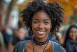A young woman with curly electric blue Jheri curl hair and a backpack is smiling for the camera at a fun fashion design event