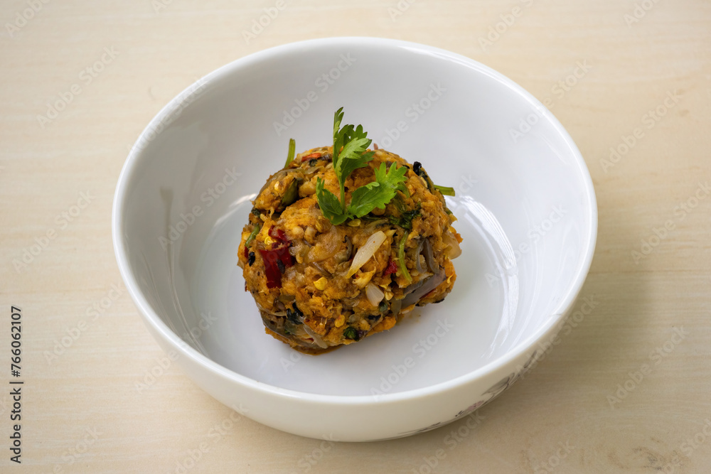 Rui Fish Bharta is served in a white ceramic bowl on a wooden textured background. Bhorta is the simplest and traditional food from Bangladesh and the Bengal region of India. Rui Fish Bharta is served in a white ceramic bowl on a wooden textured background. Bhorta is the simplest and traditional food from Bangladesh and the Bengal region of India.
