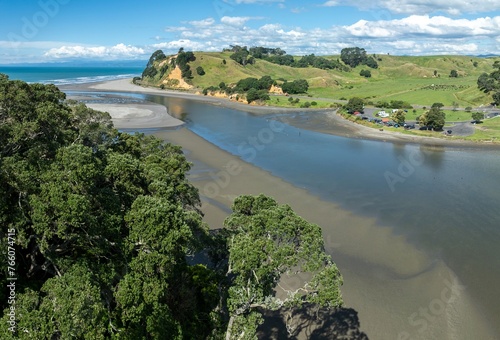 Aerial: Estuary, pohutukawa grove and sandy coastline ofWaiotahe, Ōpōtiki, Bay of Plenty, New Zealand.