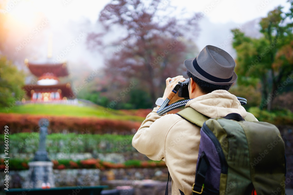 Traveller man or blogger using professional DSLR mirrorless camera take photo landscape autumn view of Katsuoji Temple, Osaka city, Japan.- Travel or tourism concept. Traveller man or blogger using professional DSLR mirrorless camera take photo landscape autumn view of Katsuoji Temple, Osaka city, Japan.- Travel or tourism concept.