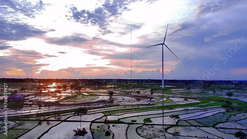 beautiful view of rice fields with a wind power plant in the background taken using a drone photo
