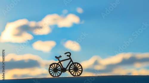 Bicycle toy shadow on silhouette, lovely bright sky as background, international bicycle day
