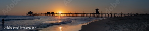 Extra Long Panorama Silhouette of Huntington Beach Pier with Distant People Watching Sunset  March 2024  California  USA