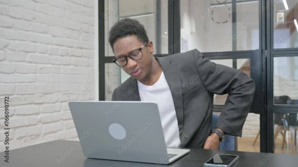 Young African Man having Back Fatigue and Pain in Office Young African Man having Back Fatigue and Pain in Office