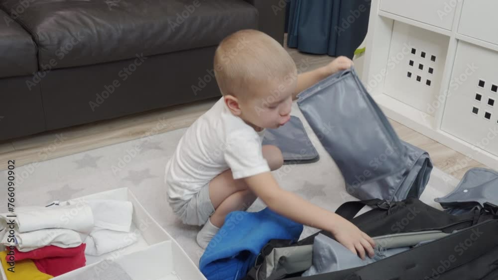 Happy child packing bags for vacation trip. little boy getting ready for holiday putting clothes in packing cubes for travel. Happy child packing bags for vacation trip. little boy getting ready for holiday putting clothes in packing cubes for travel.