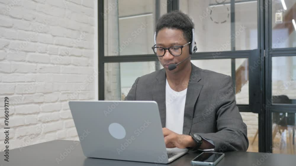 Young African Man with Headset Working on Laptop Young African Man with Headset Working on Laptop