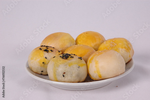 Tau Sar Piah with Sweet green been and Sweet black seeds and salted egg on a white background with a cup of hot milk tea