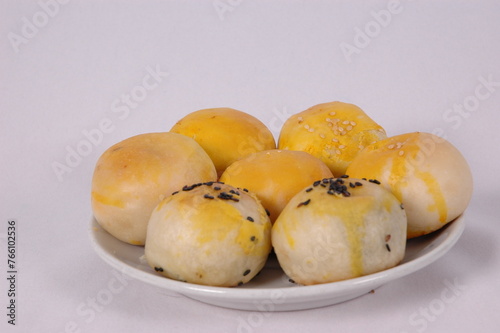 Tau Sar Piah with Sweet green been and Sweet black seeds and salted egg on a white background with a cup of hot milk tea