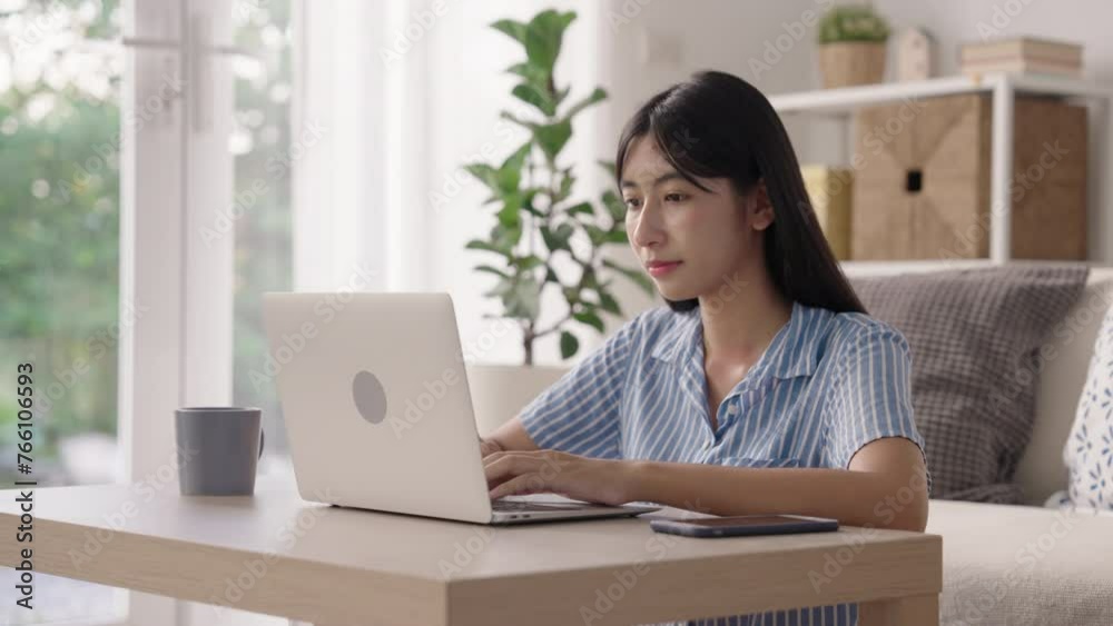 Asian girl student doing homework and learning online with tutor on laptop, Asia woman typing work on computer , Concept of online learning at home Asian girl student doing homework and learning online with tutor on laptop, Asia woman typing work on computer , Concept of online learning at home