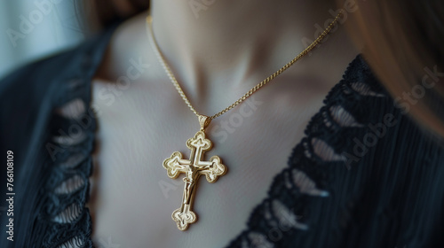 A golden cross pendant on the neck of a woman. Faith concept.