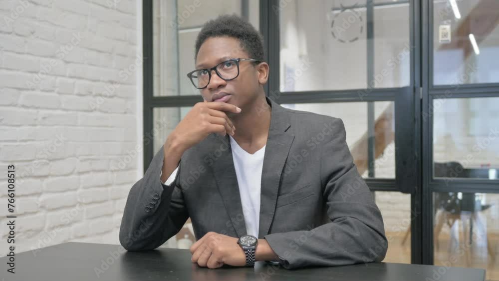 Pensive Young African Man Brainstorming while at Work Pensive Young African Man Brainstorming while at Work