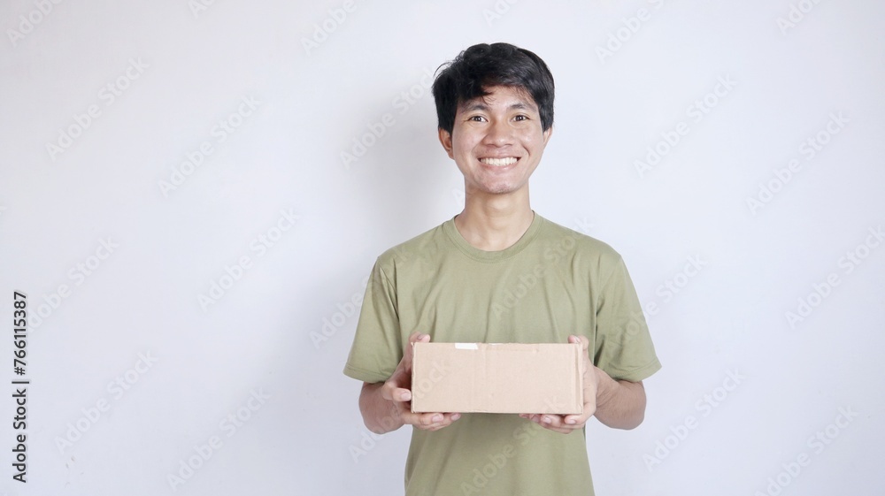 Smiling Asian man shows the package he is holding on
