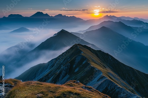 Majestic sunrise over misty mountain peaks with a clear sky.