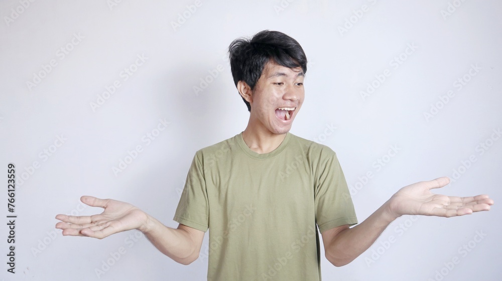 young asian man excited showing something in both hands young asian man excited showing something in both hands