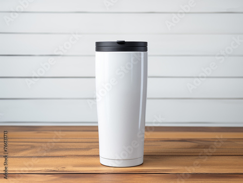моск up  white tumbler with black lid stands on a light wood countertop against a light gray wall