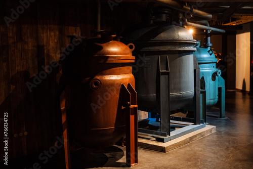 Two large metal tanks sit in a dark room next to each other