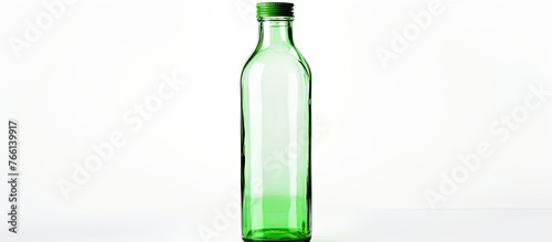 A green glass container featuring a cap in black color, suitable for storing liquids or beverages photo