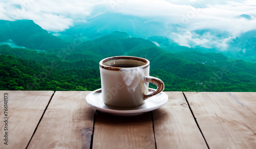 A coffee mug on the table amidst a refreshing mountain view.