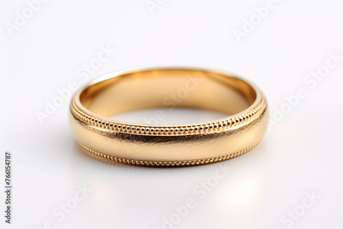 a gold ring on a white surface