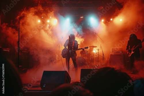 Band performing on stage enveloped in dramatic smoke