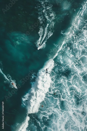 Aerial view of two surfers riding waves in the ocean
