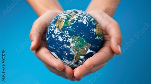 Hands holding a globe on a blue background.