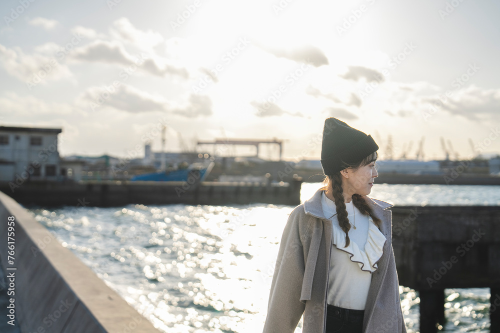 夕暮れの海を旅する女性