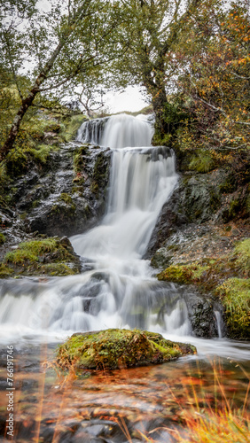 Fototapeta Naklejka Na Ścianę i Meble -  Waterfall in the forest, long exposure image, on the NC500 driving route Scotland, mobile wallpaper portrait.