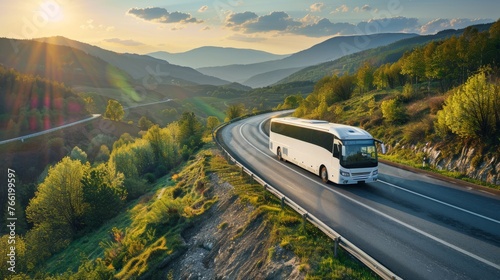 A white bus is driving down a road with mountains in the background