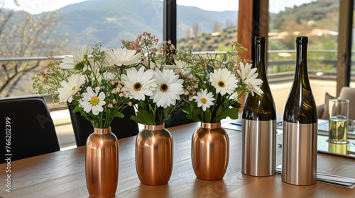  three vases with flowers in them sitting on a table next to a bottle of wine and a bottle of wine.