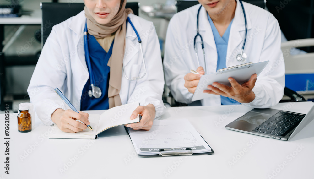 Doctors analyzing results or diagnosis of patient in clinic. Teamwork, medical and healthcare workers in discussion and research on tablet device Doctors analyzing results or diagnosis of patient in clinic. Teamwork, medical and healthcare workers in discussion and research on tablet device