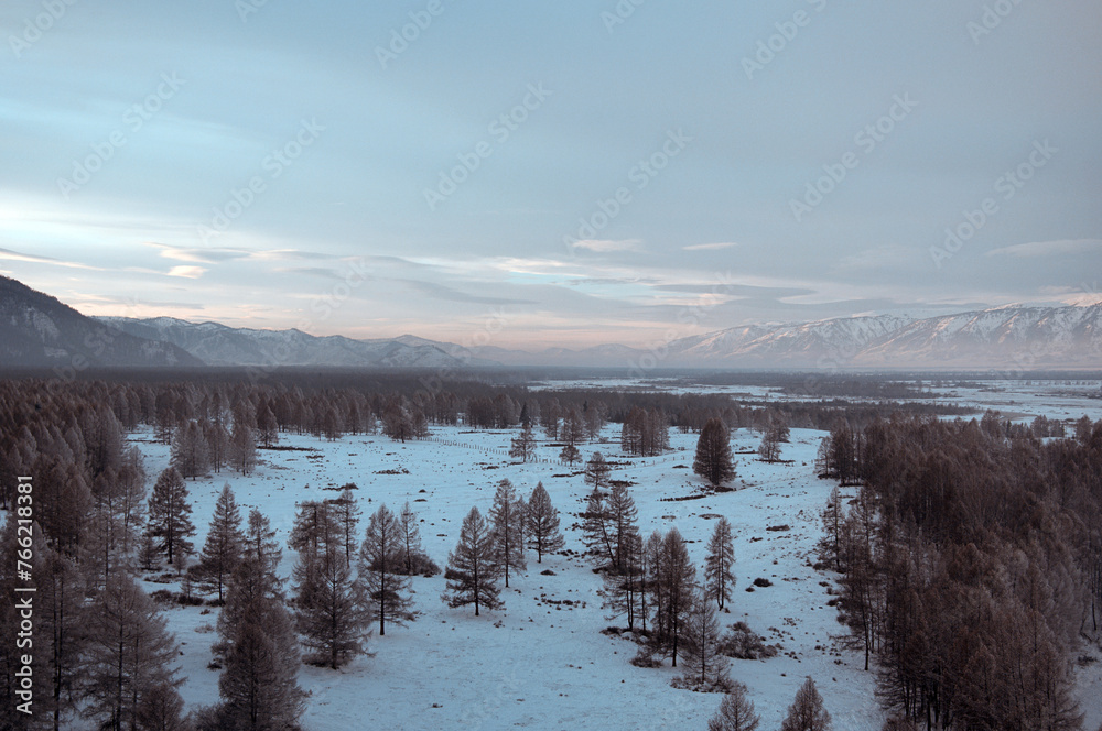 Cold snowy mountain landscape at sunset.