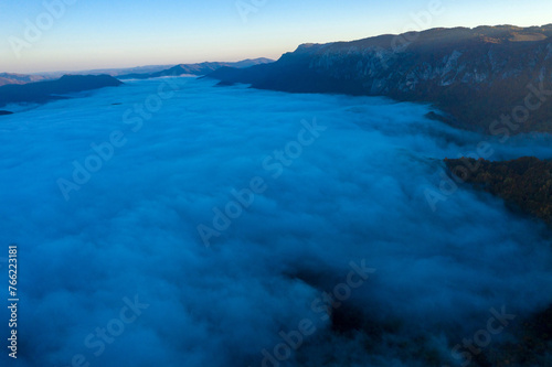 Flying above the clouds in dawn. Misty morning in the valley  aerial  view