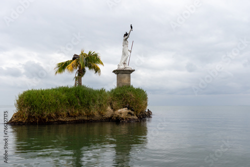 Statue in the middle of the ocean in livingstone guatemala photo